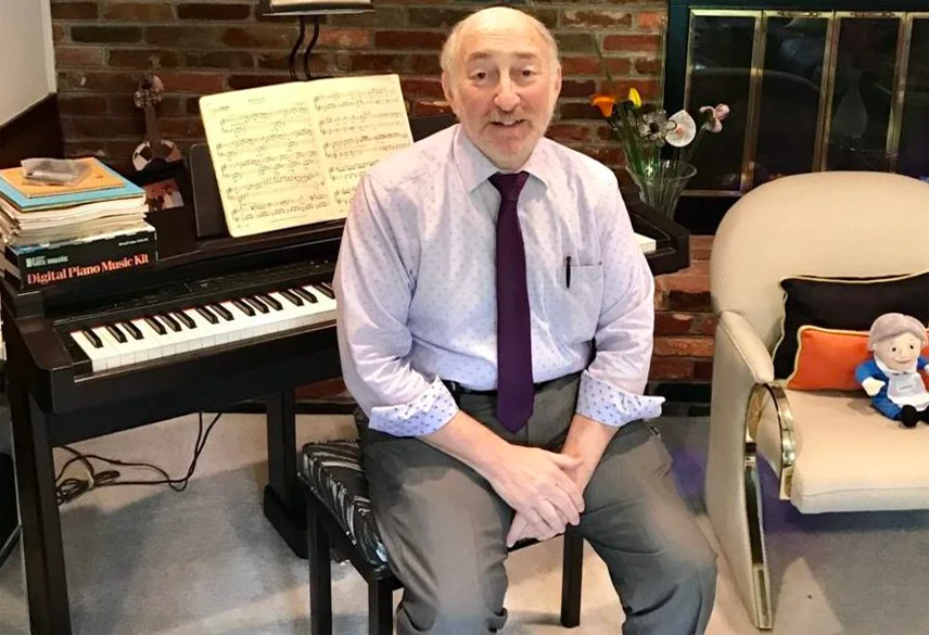 Arnold S. Kirshenbaum seated at his piano